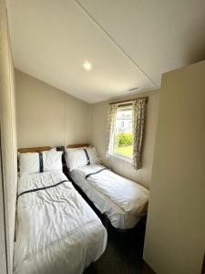 two beds in a small room with a window at Atlantic 63 in Bude