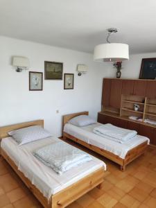 a bedroom with two beds and a cabinet with a lamp at Ciche Ranczo in Łuków