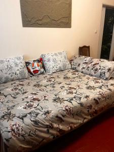 a bed with a floral comforter and pillows on it at City Relax 2 in Bălţi