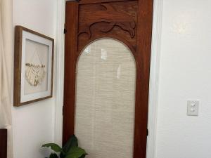 a wooden door with a mirror in a hallway at Happy Hill Inn in Kailua-Kona