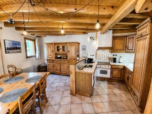 a kitchen with wooden cabinets and a wooden table with a tableablish at Villa Silote in La Grave