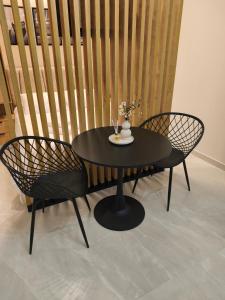 a black table with two chairs and a black table and chairs at Lounetta Apartments 1 in Missolonghi +16 photos