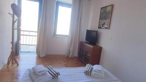 a room with a bed and a tv on a dresser at Cycladic Stone House with Pool & Sunset Views in Gialiskari