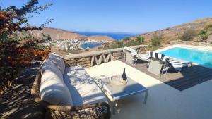 a patio with a table and a swimming pool at Cycladic Stone House with Pool & Sunset Views in Gialiskari