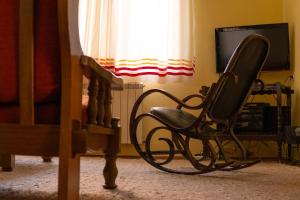 a chair sitting in front of a tv in a bedroom at Smestaj Vanja in Arilje +12 photos