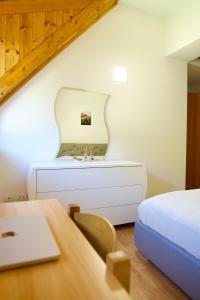 a bedroom with a bed and a desk with a mirror at Casa Azzurra - Spacious apartment in the heart of Julian Alps in Cave del Predil