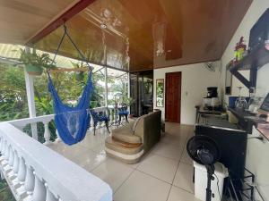 a room with a hammock on a balcony at Frías Home in Tortuguero