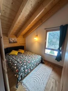 a bed in a small room with a window at Chalet cosy avec vue montagne proche La Clusaz & Le Grand-Bornand in Saint-Jean-de-Sixt