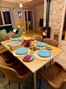 a wooden table with plates of food on it at Chalet cosy avec vue montagne proche La Clusaz & Le Grand-Bornand in Saint-Jean-de-Sixt