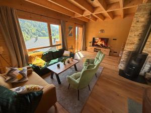 a living room with a couch and chairs and a fireplace at Chalet cosy avec vue montagne proche La Clusaz & Le Grand-Bornand in Saint-Jean-de-Sixt