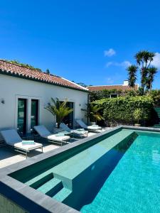 a villa with a swimming pool and a house at Maison EMERAUDE in Rabo de Peixe
