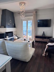a living room with a white couch and a television at SugarV Home in Kilkis