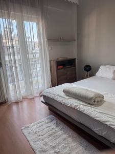 a bedroom with a white bed and large windows at SugarV Home in Kilkis