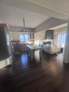 a kitchen and living room with a table and a refrigerator at SugarV Home in Kilkis