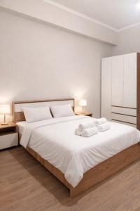 a bedroom with a large white bed with two towels at N4 Alvina Complex in Tsaghkadzor