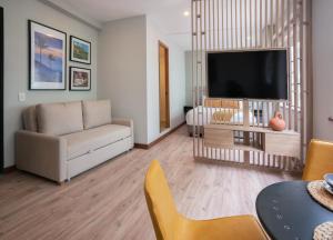 a living room with a couch and a flat screen tv at CasaSue Living & Hotel in Bogotá