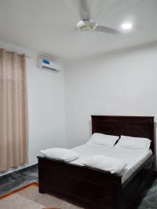 a bed in a room with a white wall at Casa del Zanzibar in Zanzibar City