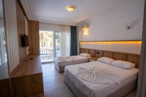 a hotel room with two beds and a television at Tunan Motel in Ayvalık +78 photos