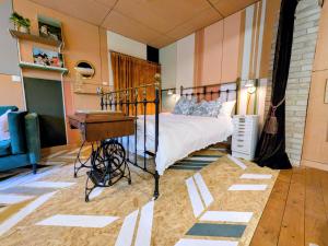 a bedroom with a bed with a desk and a piano at Woodside Studio in Hassocks
