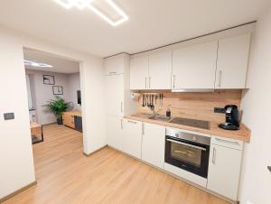 a kitchen with white cabinets and a stove top oven at Ferienwohnung MoselVino in Lieser
