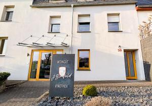a white building with a sign in front of it at Ferienwohnung MoselVino in Lieser