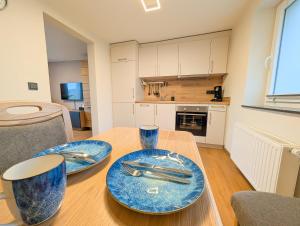 a kitchen with two blue plates on a wooden table at Ferienwohnung MoselVino in Lieser +13 photos