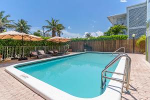 a swimming pool with chairs and umbrellas at Bayview Regency Apartments By Lowkl in Fort Lauderdale