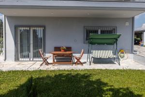 a patio with a table and chairs and a green umbrella at Lanari Valley House in Thermi +26 photos