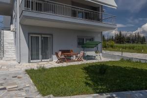 a patio with a table and a green swing at Lanari Valley House in Thermi