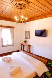a bedroom with a large bed with a tv on the wall at Anhel Hotel in Berat