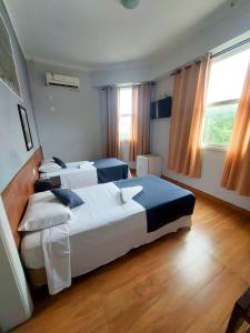 ein Hotelzimmer mit zwei Betten und einem Fenster in der Unterkunft Hotel Carioca in Rio de Janeiro + 39 Fotos