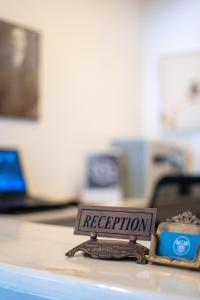 a sign that says reception on top of a counter at Tunan Motel in Ayvalık
