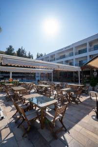 a group of tables and chairs in front of a building at Tunan Motel in Ayvalık