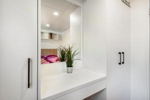 a white bathroom with white cabinets and a plant on a counter at Haus Lotte und Frieda in Riedenburg +31 photos