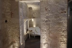 a bathroom with a white toilet in a stone wall at Relais Il Santissimo in Turi