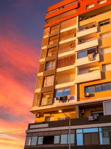 a tall building with a sunset in the background at Grand Standing 110m2 Piscine Terrasse Proche Plage in Agadir