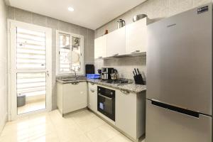a kitchen with a refrigerator and a stove top oven at Grand Standing 110m2 Piscine Terrasse Proche Plage in Agadir