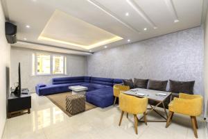 a living room with a blue couch and a table at Grand Standing 110m2 Piscine Terrasse Proche Plage in Agadir