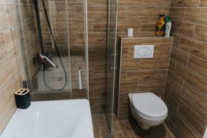 a small bathroom with a toilet and a shower at Stan Brana in Ruma +4 photos