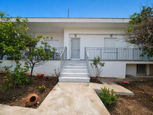 a white building with a staircase in front of it at Mentis Home in Artemida