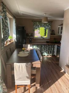 a kitchen with a wooden table and a dining room at Słoneczny domek in Brenna