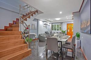 a dining room and living room with a table and stairs at Large Spacious 3BR House at BTS ON NUT in Phra Khanong
