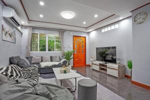 a living room with a couch and a tv at Large Spacious 3BR House at BTS ON NUT in Phra Khanong