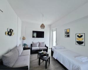 a white living room with a couch and a table at Mentis Home in Artemida