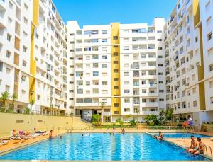a swimming pool in front of a large building at Grand Standing 110m2 Piscine Terrasse Proche Plage in Agadir