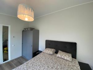a bedroom with a bed and a chandelier at Hoovimaja in Pärnu