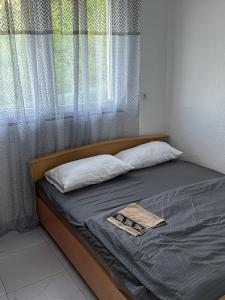 a bed with two pillows and a window at Comfort Days in Gladno Polje