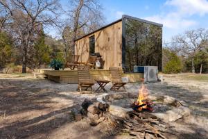 a tiny cabin with two chairs and a fire at Mod Squad in Saint Jo
