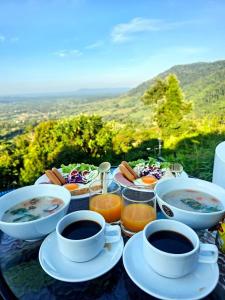 a table with cups and plates of food and drinks at Heaven Khaokho2 in Khao Kho