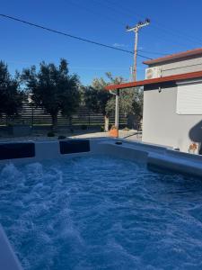 a swimming pool in front of a house at MtsHome I Luxury Stay with Jacuzzi in Áyios Spirídhon